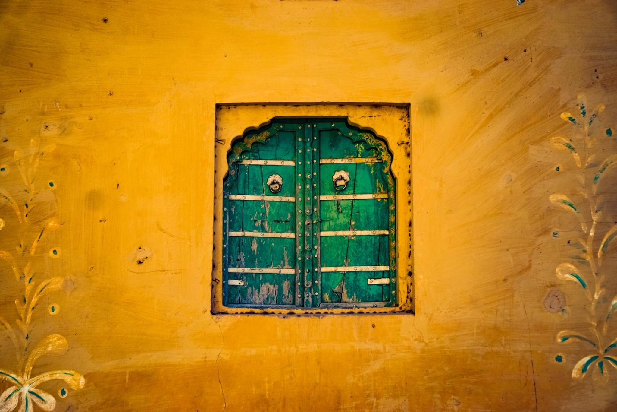 Yellow wall with green wooden shutters