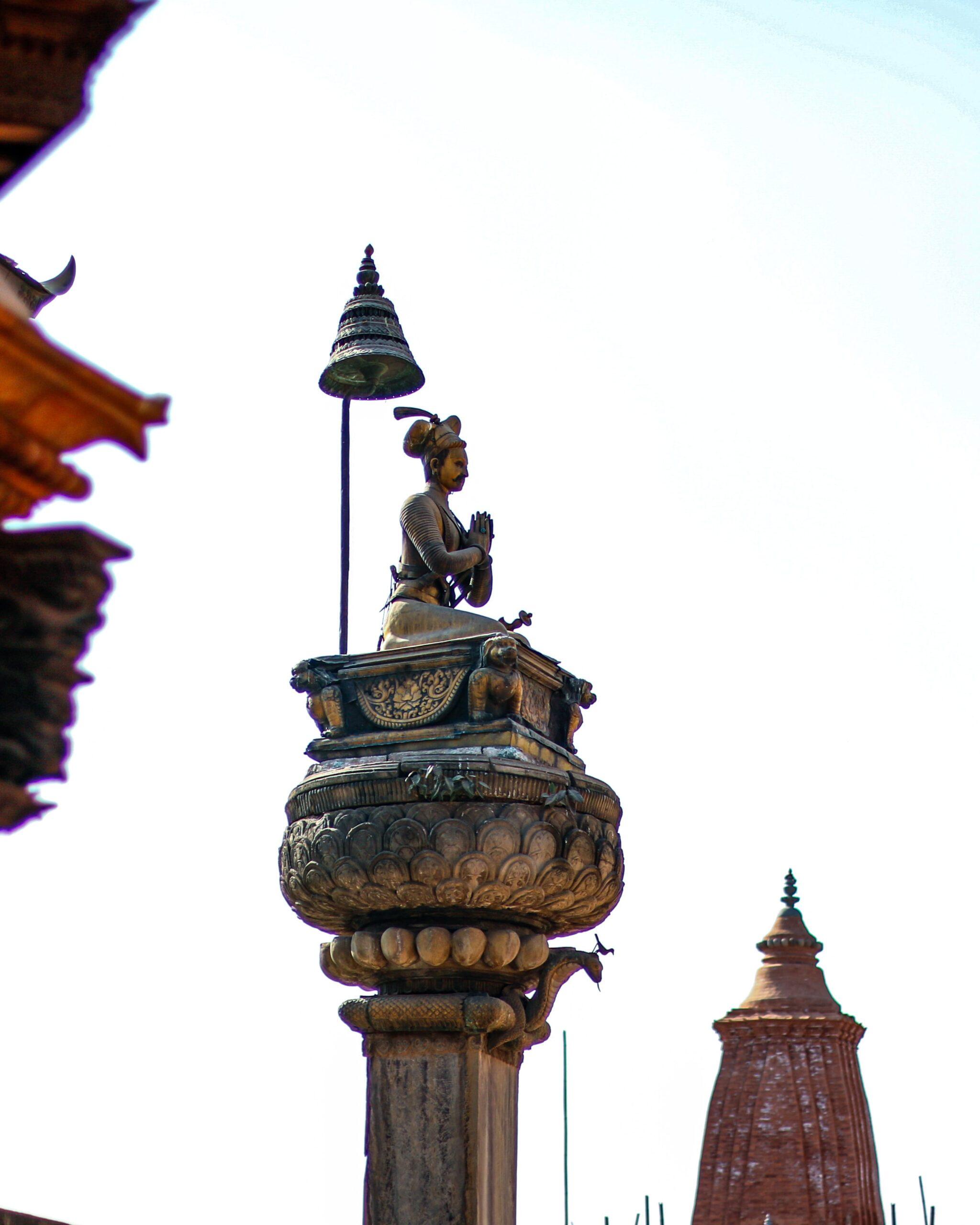 Statue of praying person atop a column