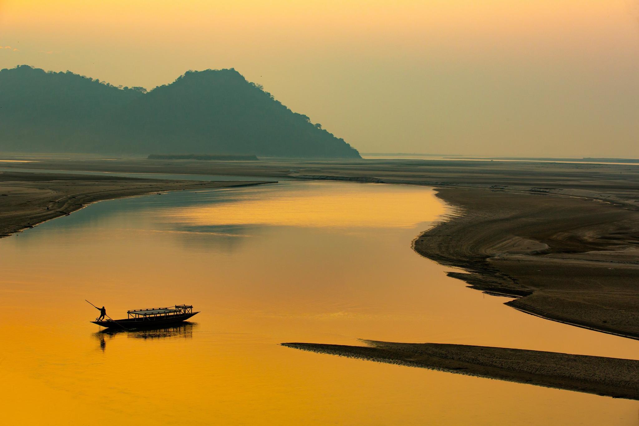 Sunset on the river,silhouette of a man rowing a boat, Mayong, Brahmaputra river, Assam, India; Photo By Jimmy Kamballur