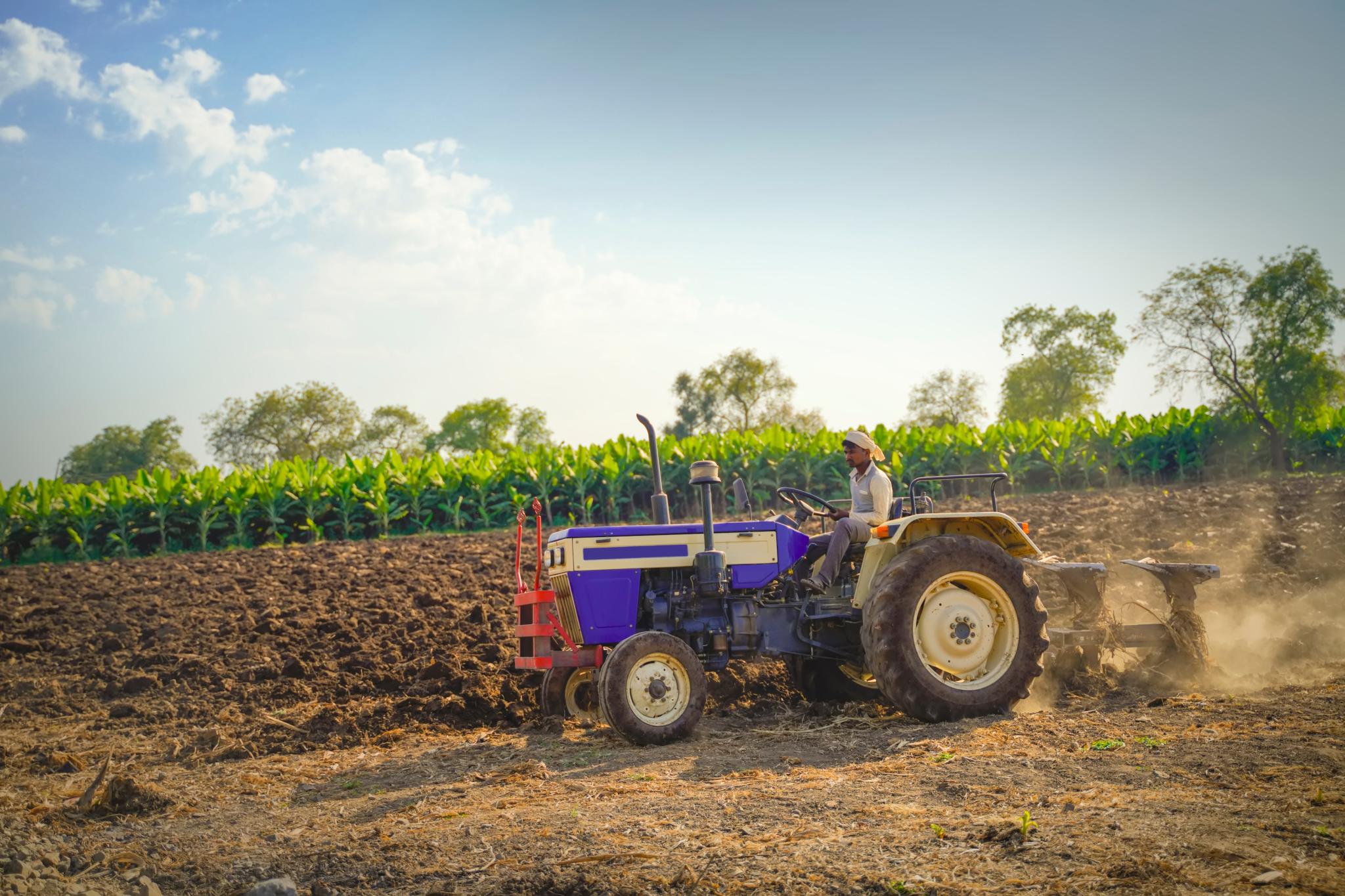 Farmer with tractor preparing land for sowing in India by PRASANNAPIX on Adobe Stock