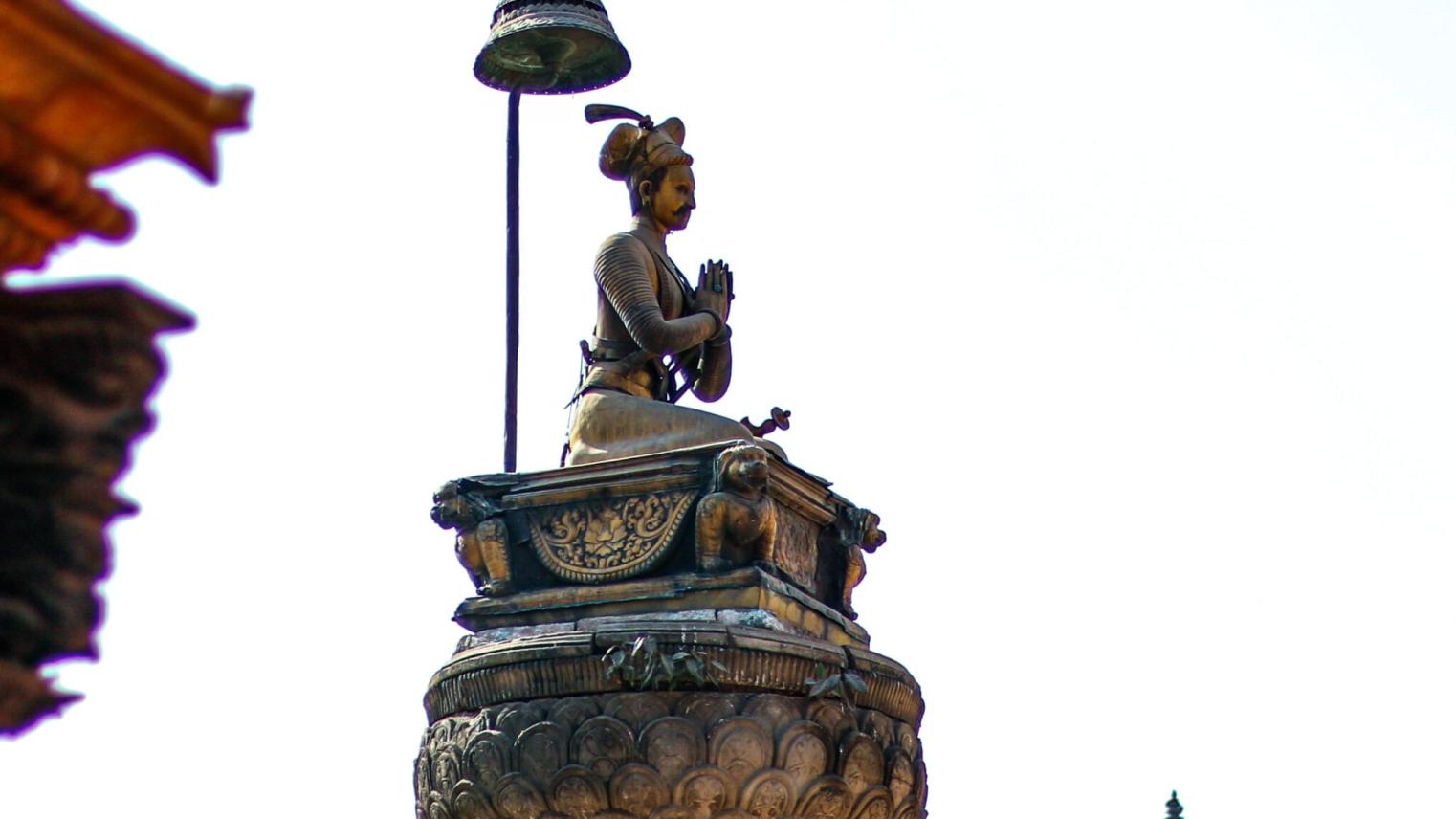 Statue of praying person atop a column